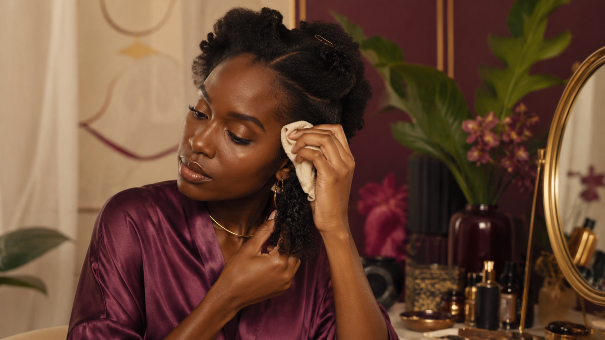 Black woman gently clearing residue after taking down braids